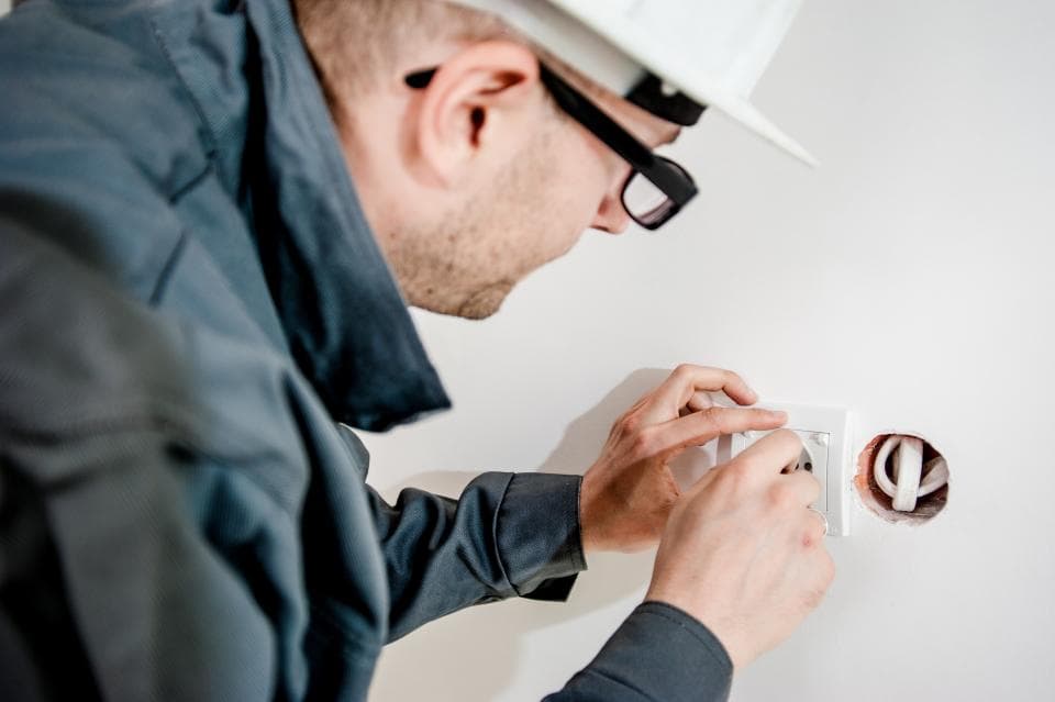 Electrician in a hard hat working on a fixture