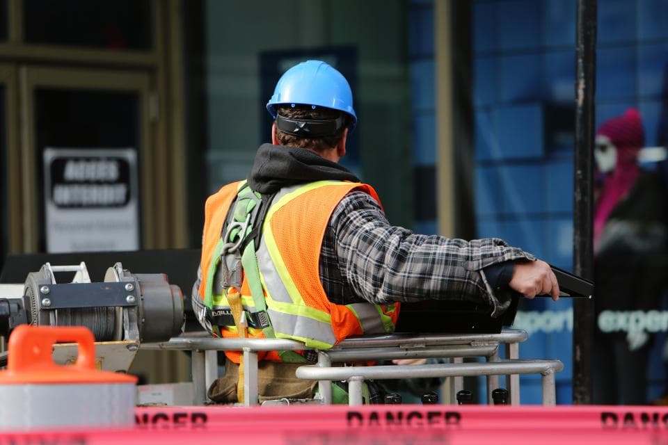 Construction worker in a hard hat and high-visibility vest on a job site